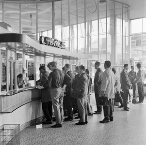 128817 Afbeelding van een rij wachtenden bij het loket van het Grenswisselkantoor in de stationshal van het Centraal ...